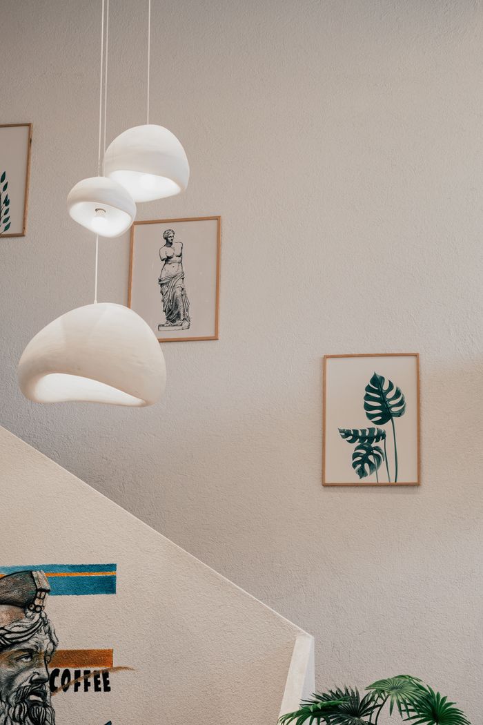 A minimalist interior featuring modern pendant lights and artistic wall decor.