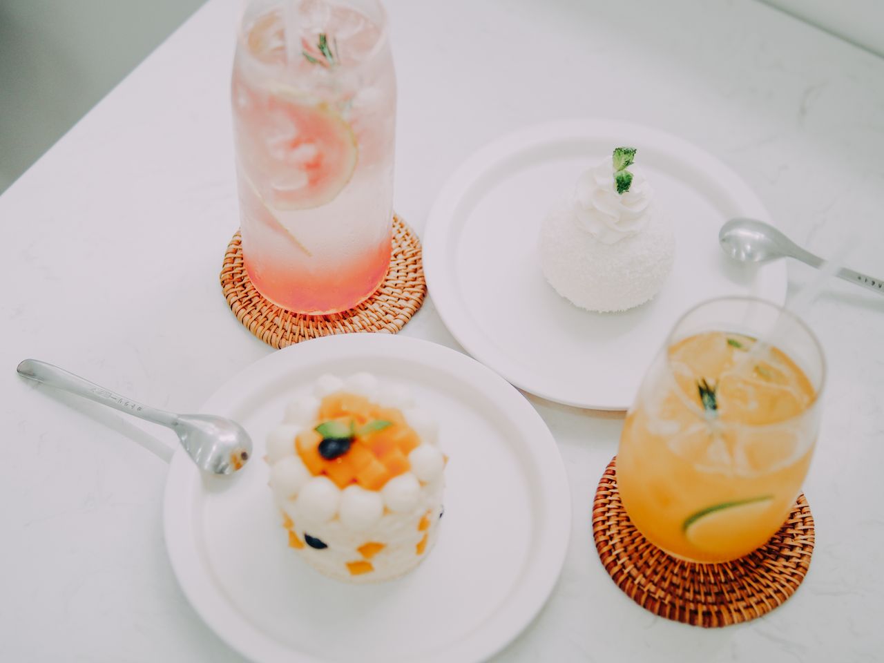 Elegant dessert and refreshing drinks displayed on white plates, perfect for a summer treat.